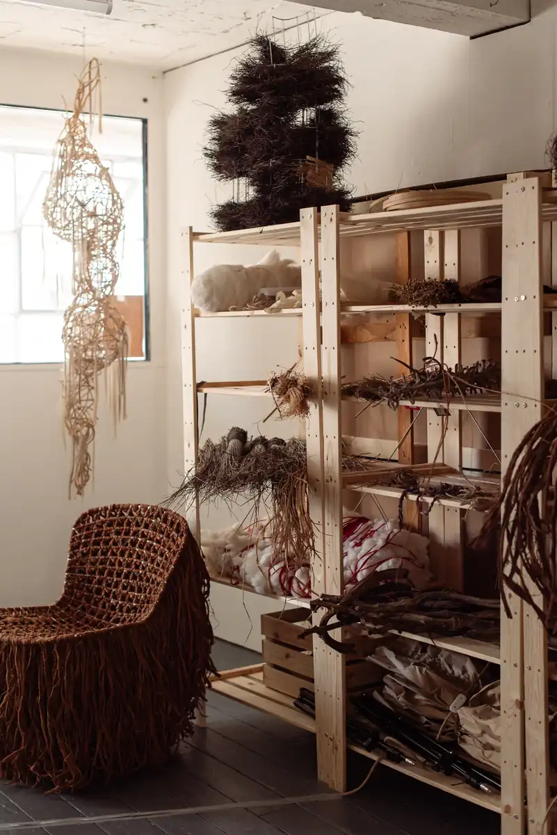 The artist's studio with shelves of fibre, bundles of material and a woven chair